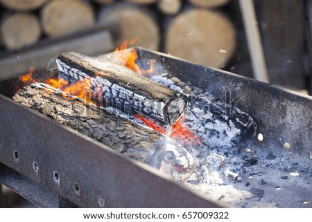 Burning coals in the grill. Charcoal barbecue blazing and growing in tray. BBQ