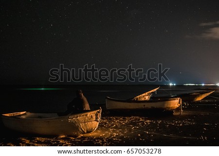 Man in  boat looks at the starry sky