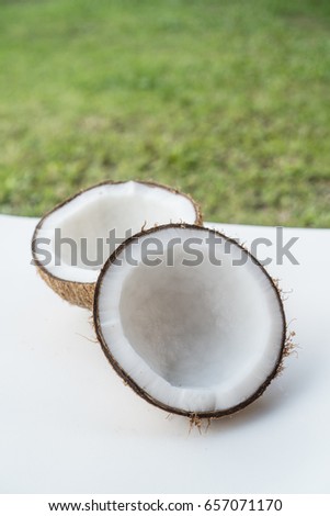 Closeup of coconuts on the white isolated over blurred grass background