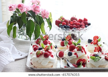 Pavlova dessert with raspberries , blueberries and strawberries on top 