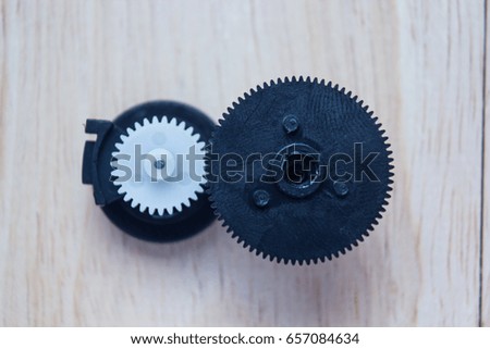 black and white cog plastic technology on wood background