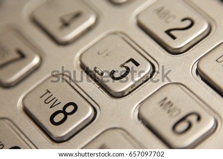 Macro Closeup of Number Digits on Silver Push-Button Phone Panel Keypad with Number 5 In Focus