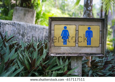 Symbolize toilets on the wooden floor,toilet sign and nature background. Wooden restroom sign