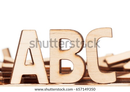 Alphabet made of wooden letters on wood background, isolated on white