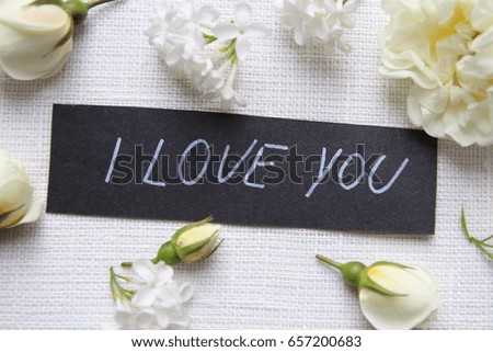 Hand writing title 'I love you' on white background. White roses