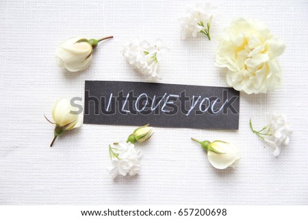 Hand writing title 'I love you' on white background. White roses