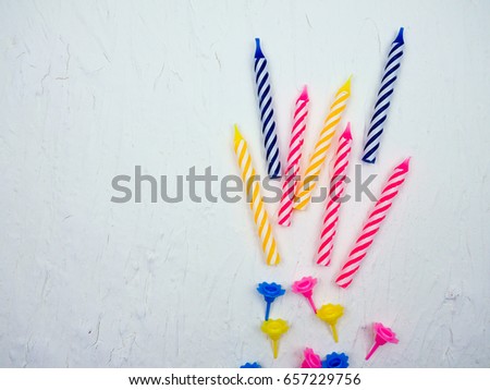 striped colorful candles for birthday party on white background. flat lay.