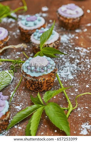 Multiple colorful nicely decorated muffins on a wooden background