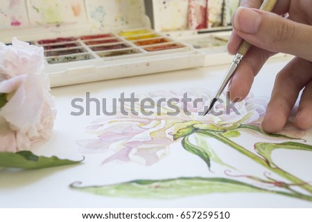 Watercolor painting. The process of drawing. The hand with a brush. The artist is painting peony picture using the brush and watercolors.