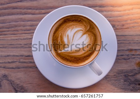 A cup of coffee late art with space on  wood background,vintage picture style