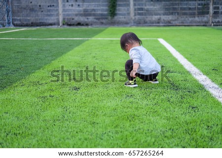 Cute asian baby girl playing on football field. Portrait of Asian beautiful baby girl of 1 year and 3 months old. 