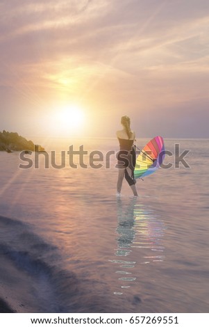 Woman holding colorful umbrella and walking on the sea. Sunrise sea and woman with umbrella in hand