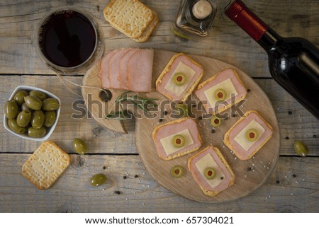 Sandwiches with crackers and olives on a wooden background