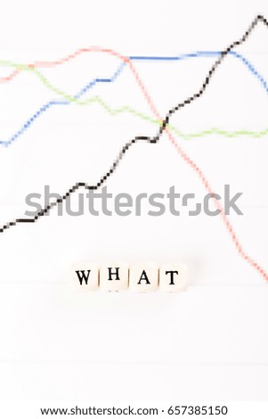 WHAT written with wood cubes letters on financial business graph