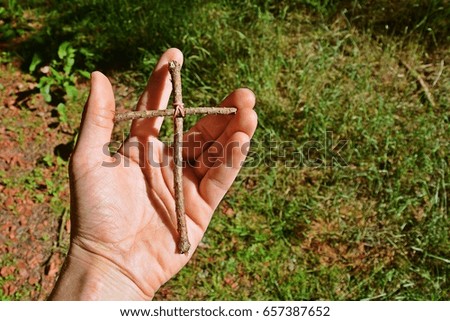 holding a self made cross in the hand