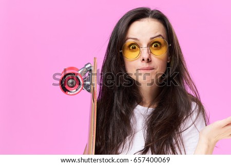 Woman with glasses, woman with skateboard on a pink background                               