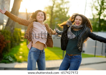 Two cheerful young women. Girlfriends dance. Wonderful spring day. Excellent mood.