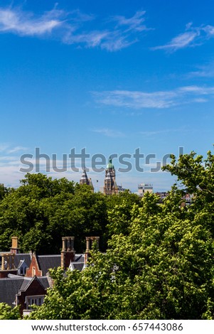 The Queen's Tower of Imperial College London as viewed across the tree filled skyline of West London