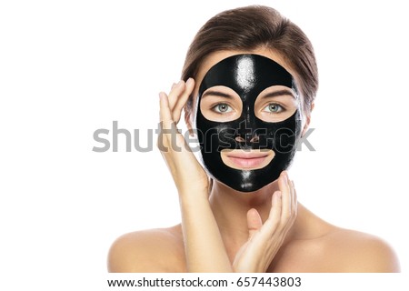 Woman with purifying black mask on her face isolated on white background Royalty-Free Stock Photo #657443803