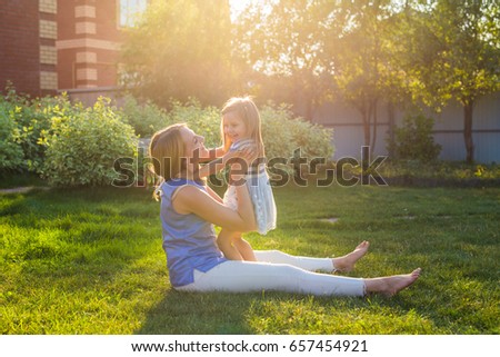 happy family mother and daughter hugging in summer on the nature