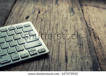 Picture of a silver keyboard on wood table.