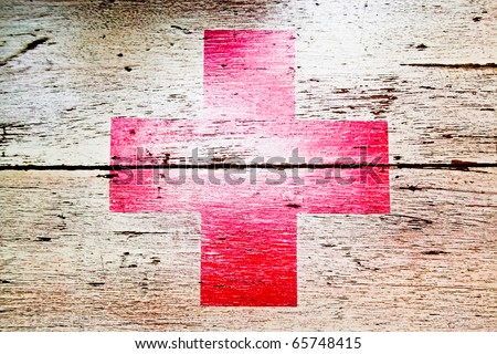 red cross on wooden background