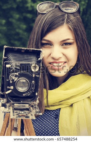 Portrait of a beautiful young girl with a retro camera. Retro style.