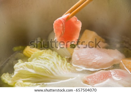 Shabu-shabu, traditional Japanese food. Raw sliced meat dipping into boiled water.
