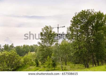 Construction of new house or building. Details. Unfinished cement building in the summer. The introduction of urbanization into nature. Capital construction in Ukraine