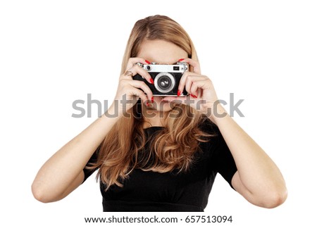 Young woman photographer holding camera and taking picture
