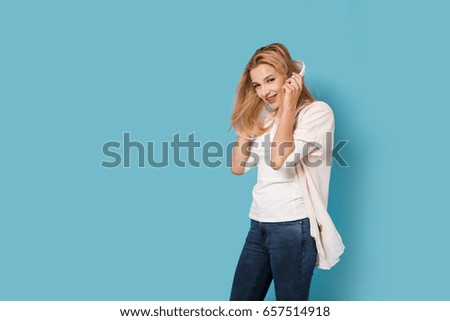 Cheerful girl with headphones isolated on blue background