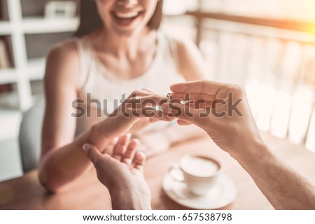 Finally! Happy moment of making proposal. She said 'Yes! 'Cropped image of young beautiful couple in cafe. Royalty-Free Stock Photo #657538798
