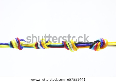 Multicolored ropes and knotted ties on a white background.
