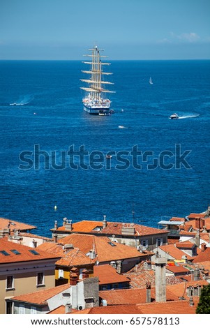 Large sailing ship with five masts anchored in the open sea near old city Piran, Slovenia.