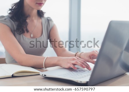 Side view photo of a female blogger, posting information in social network, using laptop, teleworking.