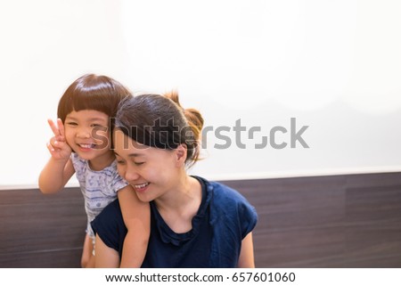 Happy loving family.Asian mother and child girl playing,kissing and hugging.