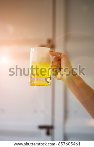 Hand holding glass of drink. Editing by removing some objects from the image.