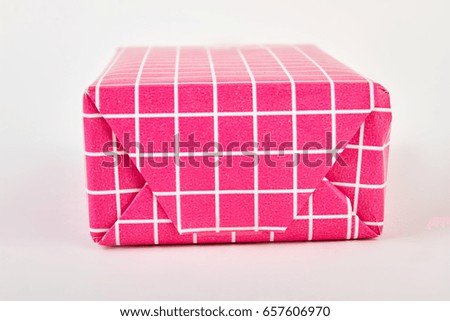 Closeup pink box for birthday. Packaged gift in pink paper.