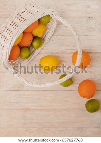 Citrus fruits - lemons, oranges and limes on a light wooden background. Selective focus.