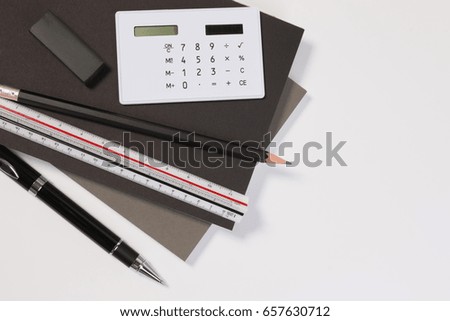 Top view. Modern business office desk table with modern business supplies book, pen ruler and calculator. Business office desk workplace with copy space in black and white tone.