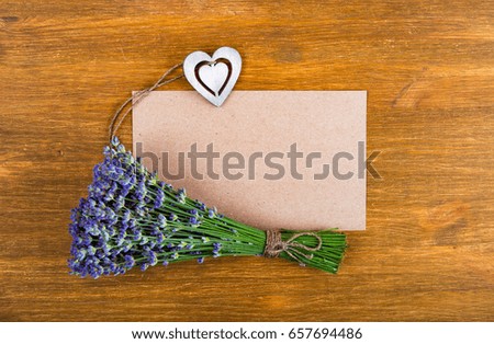 Lavender flowers, blank sheet of paper and heart on a old wooden background