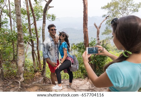 Girl Taking Photo Of Couple With Backpacks Posing Over Mountain Landscape On Cell Smart Phone, Trekking Young Man And Woman Group On Hike Tourists Adventure Activity
