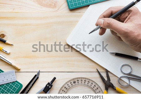 Top view of male hand on wood table with elements of tools,equipment.Creativity decoration design and handmade concepts background