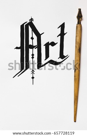 Art calligraphy background top view. Word drawn with ink and feather. Painter workshop, business inspiration, creativity concept