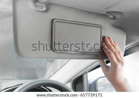 woman hand holding sun visor interior inside car Royalty-Free Stock Photo #657739171
