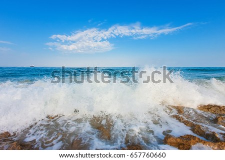 Huge wave breaking over rocks with dramatic foam and brilliant sea coast line morning,Cyprus, Pafos