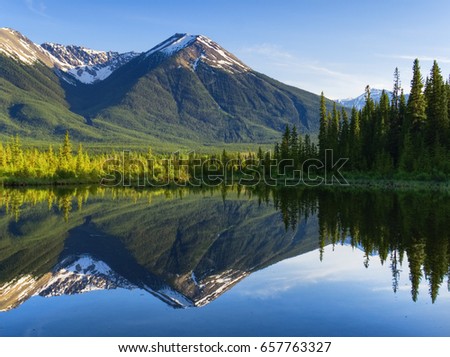 Rocky Mountains and Trees Reflecting on Lake in Banff    