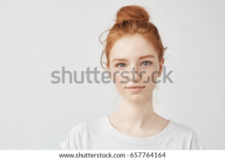 Portrait of beautiful redhead girl smiling looking at camera. Royalty-Free Stock Photo #657764164