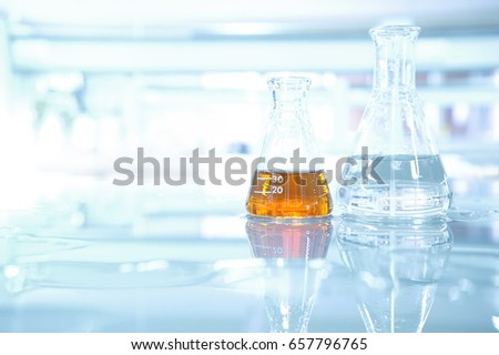 orange liquid and water in flask on science table laboratory   Royalty-Free Stock Photo #657796765