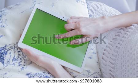 woman is relaxing on comfortable couch and using tablet at home
